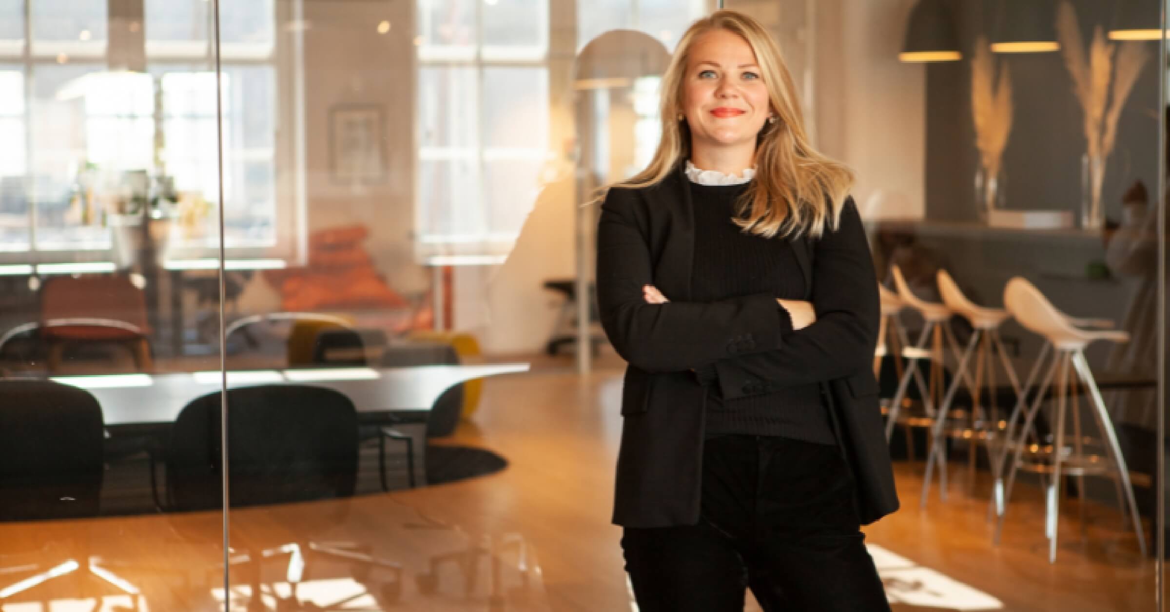 Guro Lindebjerg smiler til kamera i kontorlandskap